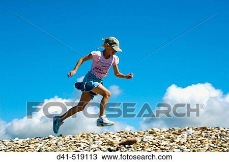 Girl running along seaside kicking View Large Photo Image Stock Image - Girl running along seaside kicking. Fotosearch