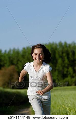 Girl running in field View Large Photo Image Stock Photo - Girl running in field. Fotosearch