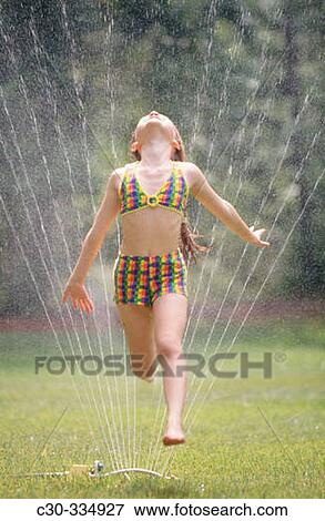 Girl running through lawn sprinkler on summer's day. View Large Photo Image Stock Photo - Girl running through lawn sprinkler on summer's day.. Fotosearch
