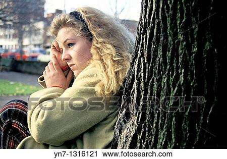girl seated by tree day dreaming View Large Photo Image Stock Image - girl seated by tree day dreaming. Fotosearch