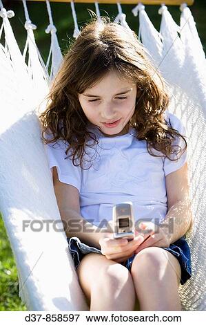Girl sending a message with a cell phone View Large Photo Image Stock Photo - Girl sending a message with a cell phone. Fotosearch