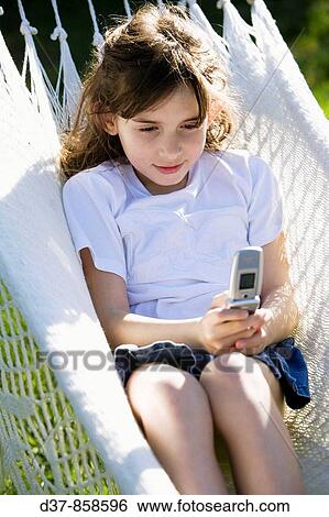 Stock Photograph - Girl sending a message with a mobile phone. Fotosearch