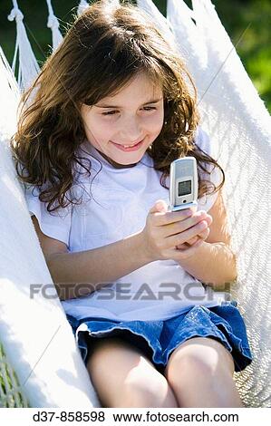 Stock Photo - Girl sending a message with her mobile phone. Fotosearch