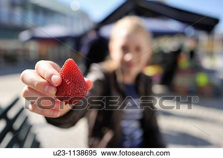 Girl showing the seasons first strawberry View Large Photo Image Stock Photography - Girl showing the seasons first strawberry. Fotosearch