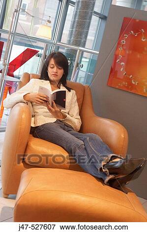 Stock Photo - girl sitting in chair reading a book. Fotosearch