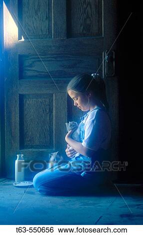 Stock Photograph - Girl sitting in house with kittens with dish of milk.. Fotosearch