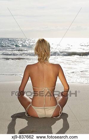 Stock Image - Girl sitting on beach.. Fotosearch