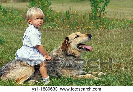 Stock Image - Girl sitting on her Dog. Fotosearch