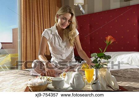 Girl sitting on the bed and breakfast. View Large Photo Image Stock Photo - Girl sitting on the bed and breakfast.. Fotosearch