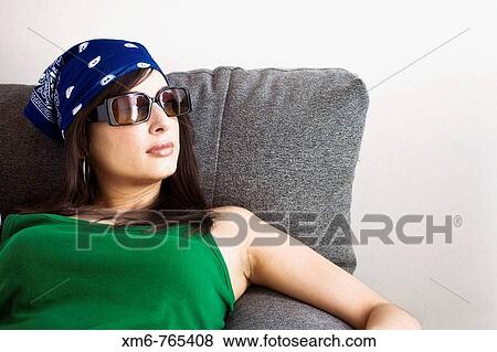 Girl sitting on the couch by the window looking pensive View Large Photo Image Stock Photo - Girl sitting on the couch by the window looking pensive. Fotosearch