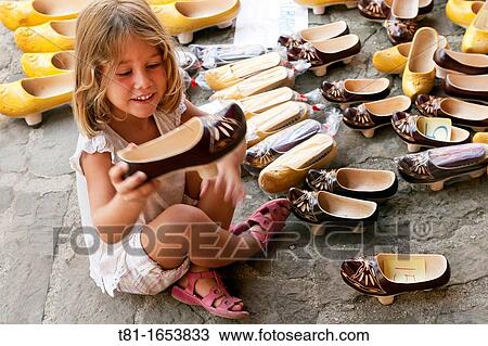 Girl sitting on the floor picking up a shoe View Large Photo Image Stock Image - Girl sitting on the floor picking up a shoe. Fotosearch