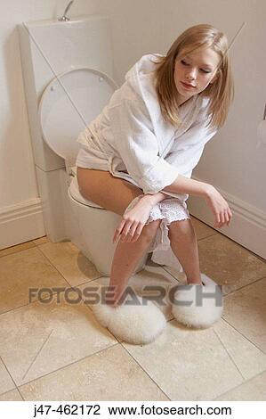 Girl sitting on the toilet with pants round her ankles View Large Photo Image Stock Image - Girl sitting on the toilet with pants round her ankles. Fotosearch