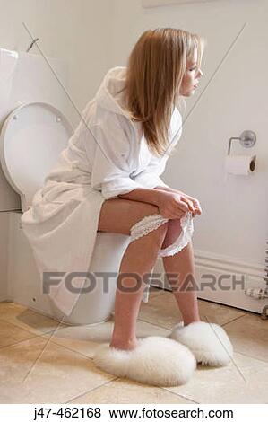 Girl sitting on the toilet with pants round her ankles View Large Photo Image Stock Photo - Girl sitting on the toilet with pants round her ankles. Fotosearch