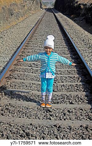 Girl Standing on railroad track, India View Large Photo Image Stock Image - Girl Standing on railroad track, India. Fotosearch