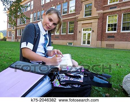 Girl studying on lawn outside school View Large Photo Image Stock Image - Girl studying on lawn outside school. Fotosearch