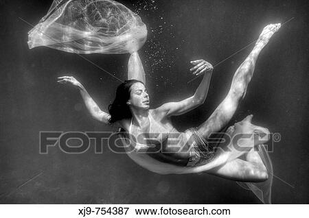 Stock Photo - Girl swimming underwater, diving angel.. Fotosearch
