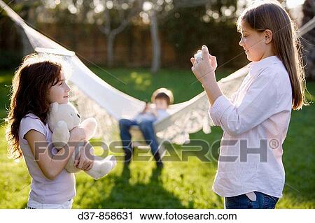 Girl taking a photo of her friend View Large Photo Image Stock Image - Girl taking a photo of her friend. Fotosearch