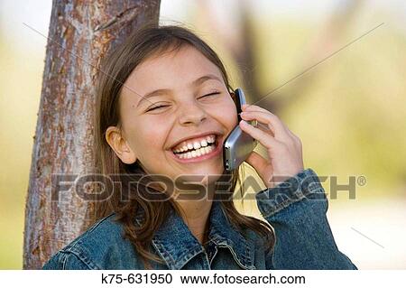 Stock Image - Girl talking and laughing on cell phone.. Fotosearch