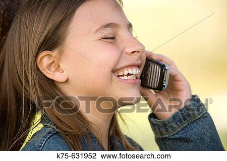 Stock Image - Girl talking and laughing on cell phone.. Fotosearch