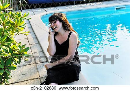 girl talking on mobile phone sitting beside a swimming pool, Ile de France region, France, Europe. View Large Photo Image Stock Photograph - girl talking on mobile phone sitting beside a swimming pool, Ile de France region, France, Europe.. Fotosearch
