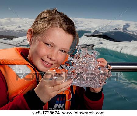 Picture - Girl tasting glacial ice, Jokulsarlon Glacial Lagoon, Iceland. Fotosearch