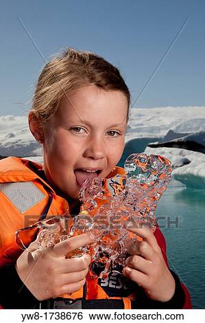 Stock Photograph - Girl tasting glacial ice, Jokulsarlon Glacial Lagoon, Iceland. Fotosearch