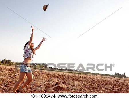 girl throwing a hat into the air View Large Photo Image Picture - girl throwing a hat into the air. Fotosearch