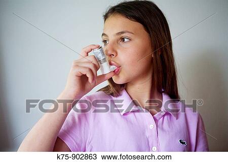 Stock Image - Girl using bronchial inhaler. Fotosearch