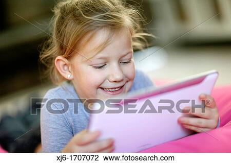 Girl using tablet computer View Large Photo Image Stock Image - Girl using tablet computer. Fotosearch