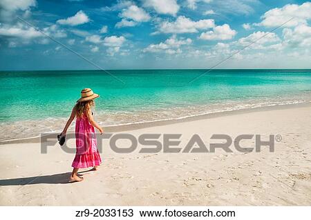 Girl walking along an empty beach in Turks & Caicos Islands. View Large Photo Image Stock Image - Girl walking along an empty beach in Turks & Caicos Islands.. Fotosearch