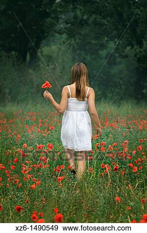 Stock Photo - Girl walking at poppies field. Fotosearch