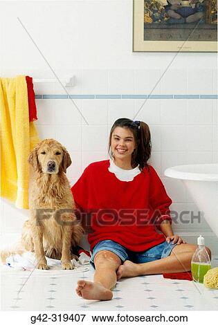 Stock Photo - Girl washing her dog in the bathroom. Fotosearch