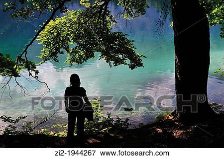 Girl watching the lake Fusine, Julian Alps. Italy View Large Photo Image Stock Photo - Girl watching the lake Fusine, Julian Alps. Italy. Fotosearch