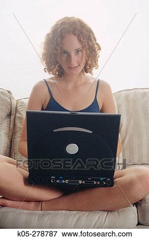 Stock Photo - Girl wearing blue tank top using laptop. Fotosearch