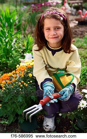 Girl wearing gardening gloves, planting flowers in garden. View Large Photo Image Stock Photography - Girl wearing gardening gloves, planting flowers in garden.. Fotosearch