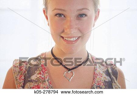 Girl wearing heart shaped pendant View Large Photo Image Picture - Girl wearing heart shaped pendant. Fotosearch