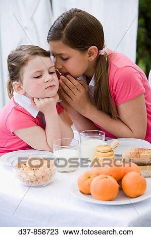 Girl whispering to her sister View Large Photo Image Stock Image - Girl whispering to her sister. Fotosearch