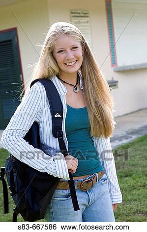 Stock Photograph - Girl with a backpack in the school yard. Fotosearch