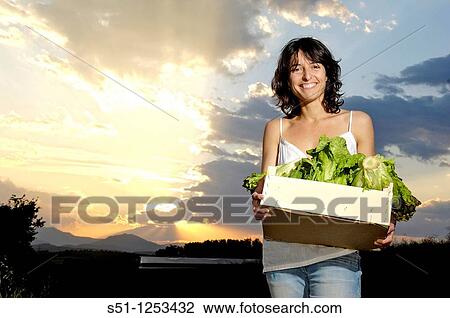 Stock Image - girl with a box of lettuce. Fotosearch