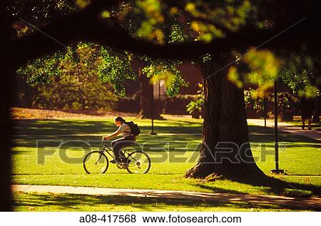 Girl with backpack rides bike across college campus. Pennsylvania, USA View Large Photo Image Stock Photo - Girl with backpack rides bike across college campus. Pennsylvania, USA. Fotosearch