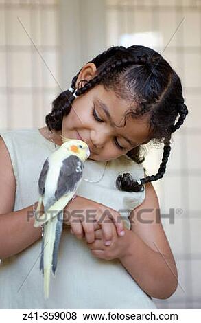 Stock Photo - Girl with cockatiel (Nymphicus hollandicus). Fotosearch