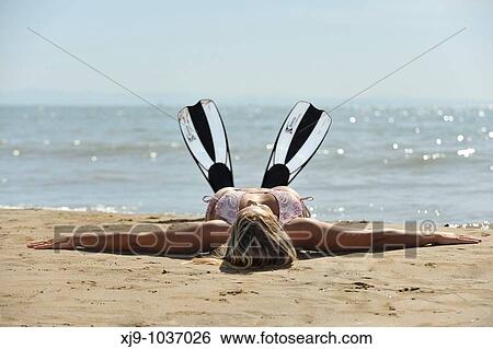 Girl with diving fins lying on the beach View Large Photo Image Stock Photograph - Girl with diving fins lying on the beach. Fotosearch