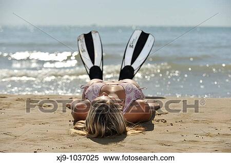 Girl with diving fins lying on the beach View Large Photo Image Stock Photography - Girl with diving fins lying on the beach. Fotosearch