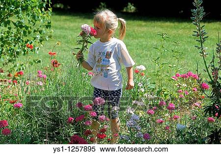 Stock Photography - Girl with flowers in garden. Fotosearch