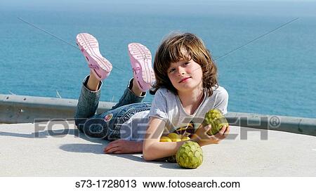 Stock Image - Girl with fruit at beach. Fotosearch