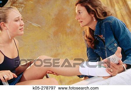 Girl with injured leg being conforted by mother View Large Photo Image Stock Photo - Girl with injured leg being conforted by mother. Fotosearch
