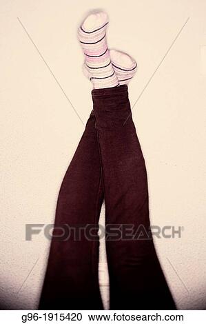 Stock Image - girl with legs propped on the wall. Fotosearch
