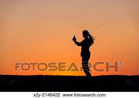 Girl with mobile phone enjoys the sunset from a jetty. View Large Photo Image Stock Image - Girl with mobile phone enjoys the sunset from a jetty.. Fotosearch