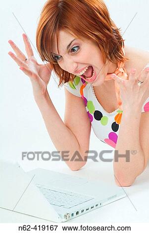 Girl with red hair screaming angry with mouth open and hands raised in front of her laptop View Large Photo Image Stock Photo - Girl with red hair screaming angry with mouth open and hands raised in front of her laptop. Fotosearch