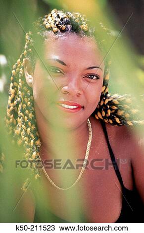 Stock Image - Girl with yellow beads in hair, smiling. Fotosearch